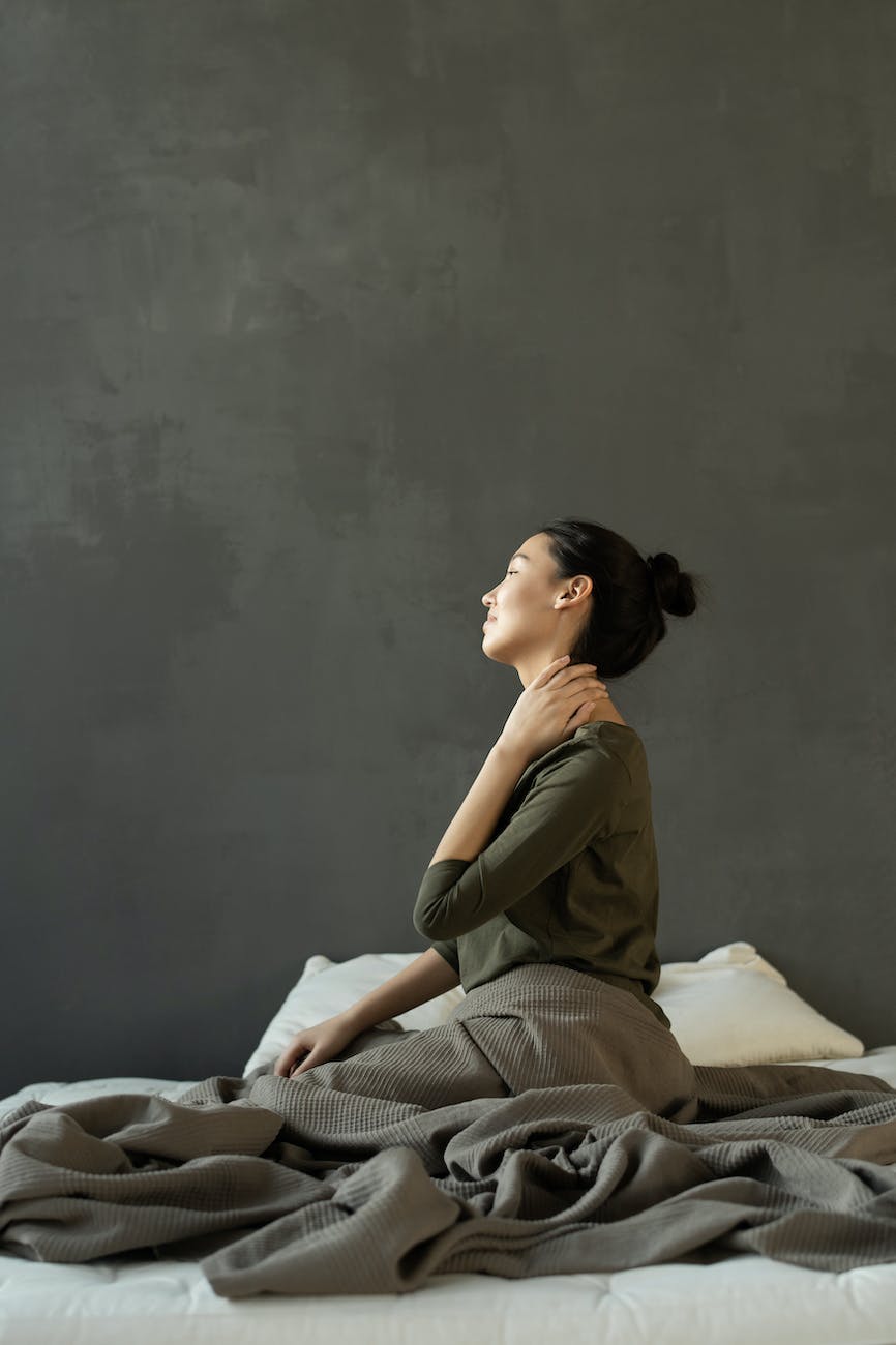 woman in gray dress sitting on bed