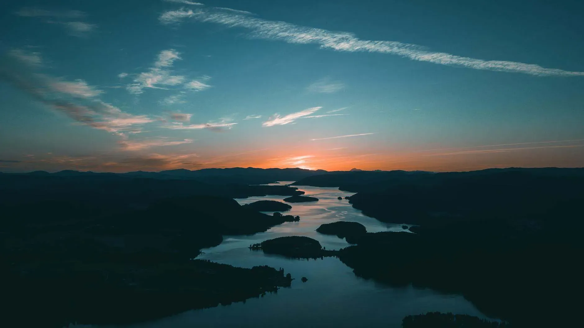 aerial photography of water beside forest during golden hour