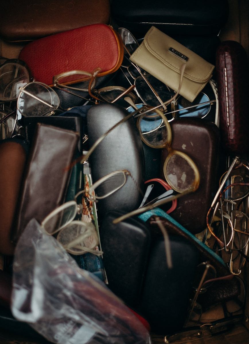 black and brown leather bifold wallet beside black framed eyeglasses