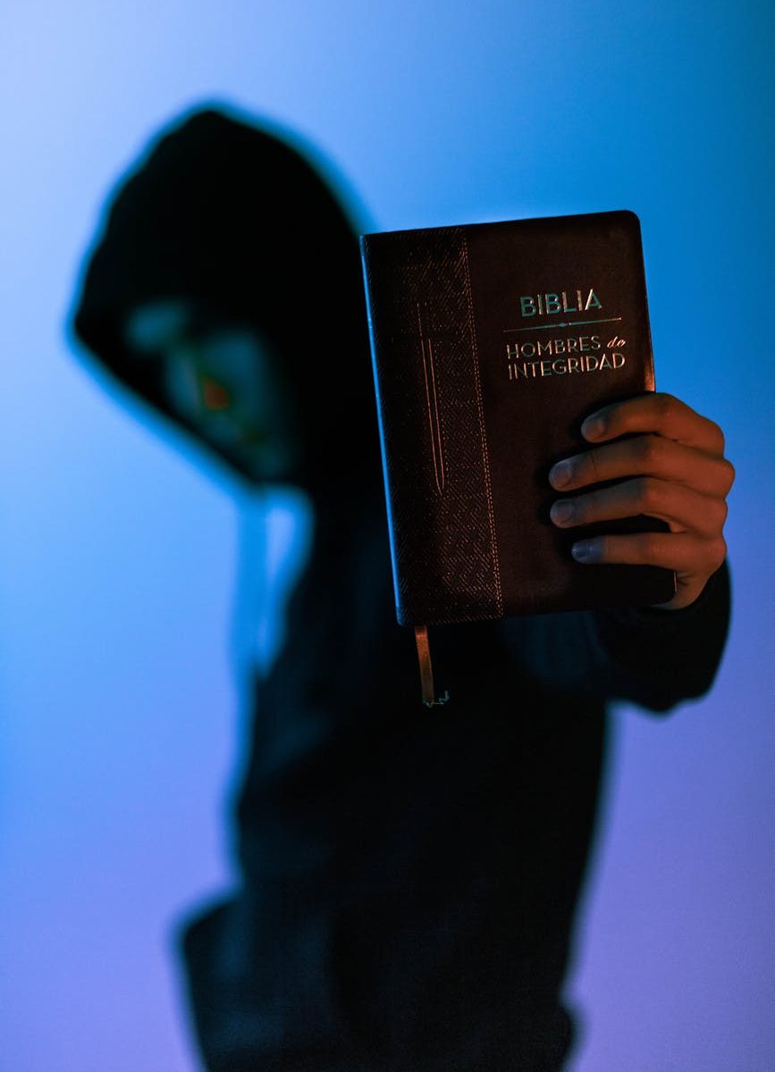 selective focus photography of man holding bible