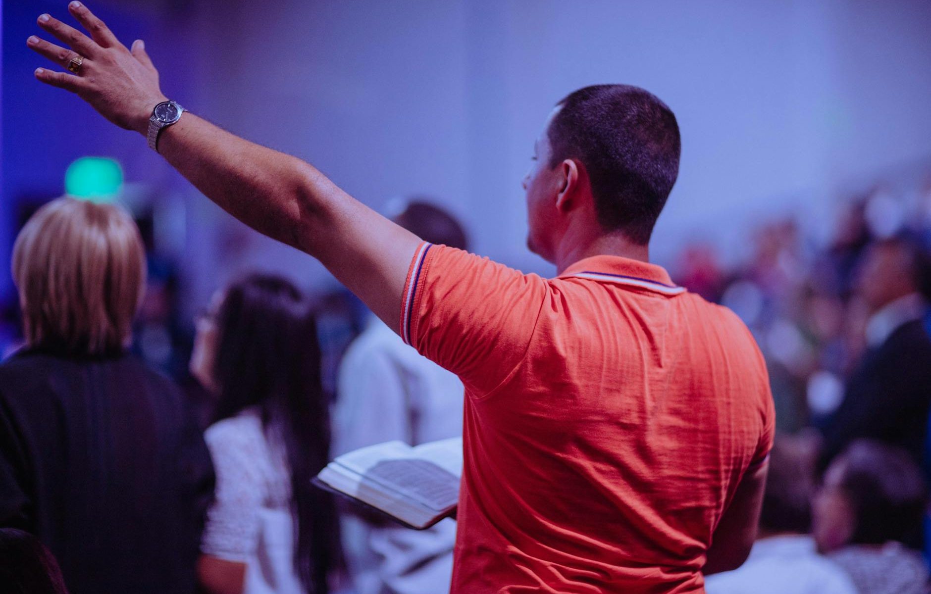 man raising his left hand