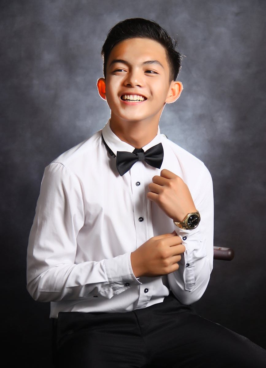 man in white dress shirt with black bowtie smiling